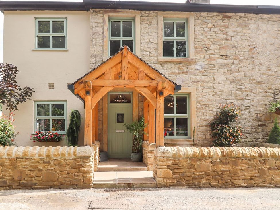 An exterior view of a cottage with a wooden porch at Cottage by the River in Burnley