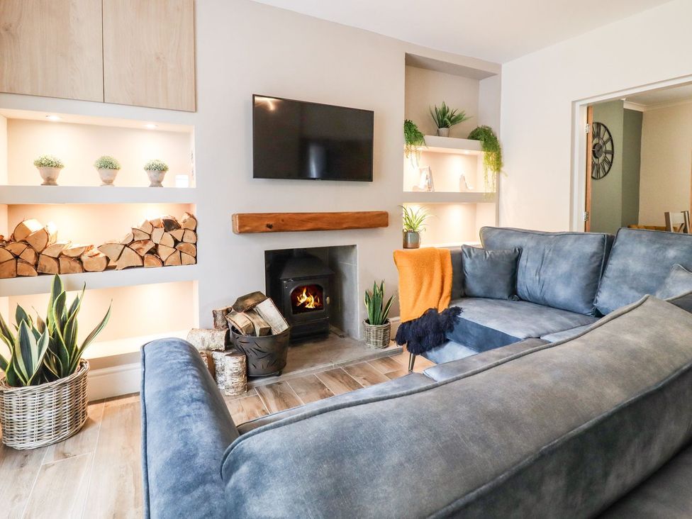 A living room with a sofa and television at Cottage by the River in Burnley