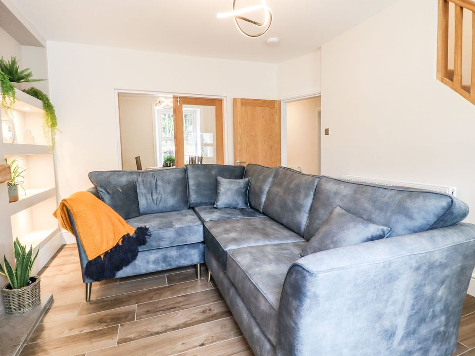 A living room with a sofa and plants at Cottage by the River in Burnley