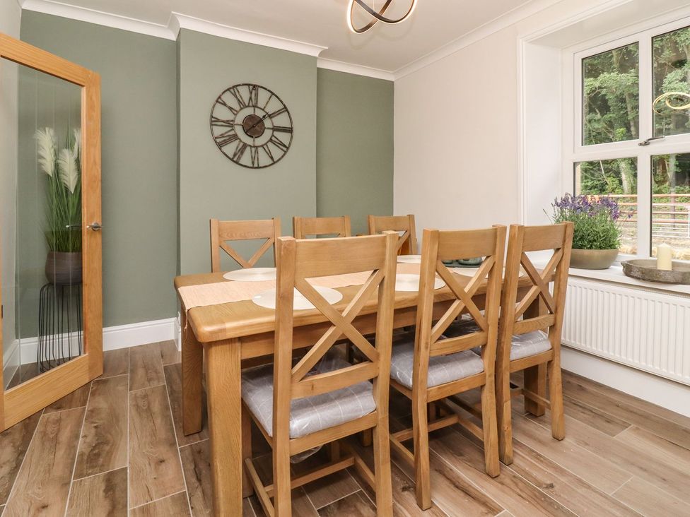A dining room with a wooden table and chairs at Cottage by the River Burnley