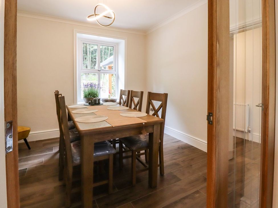 A dining room with a table and chairs at Cottage by the River in Burnley