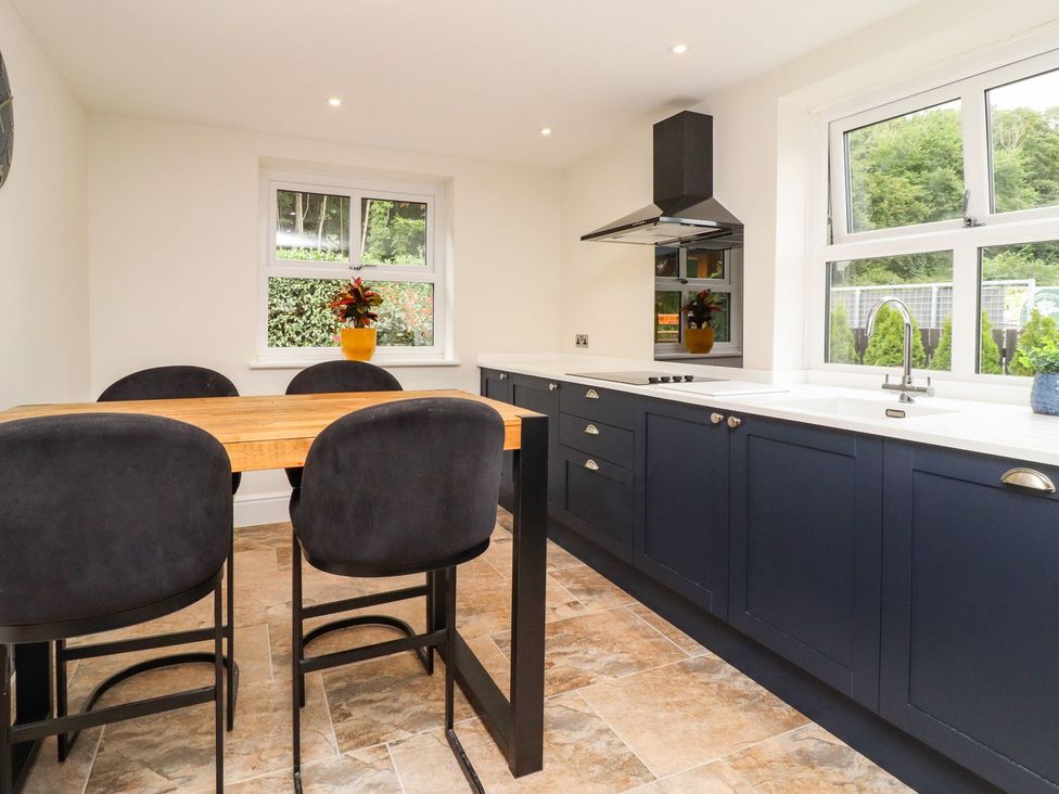 A kitchen with a dining table and chairs at Cottage by the River in Burnley