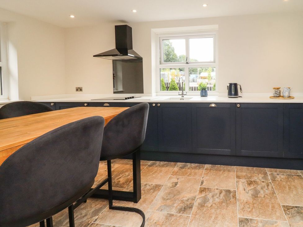A kitchen with a table and chairs at Cottage by the River in Burnley