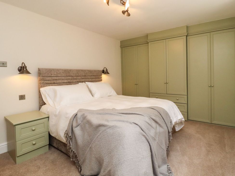A bedroom with a bed and wardrobe at Cottage by the River Burnley