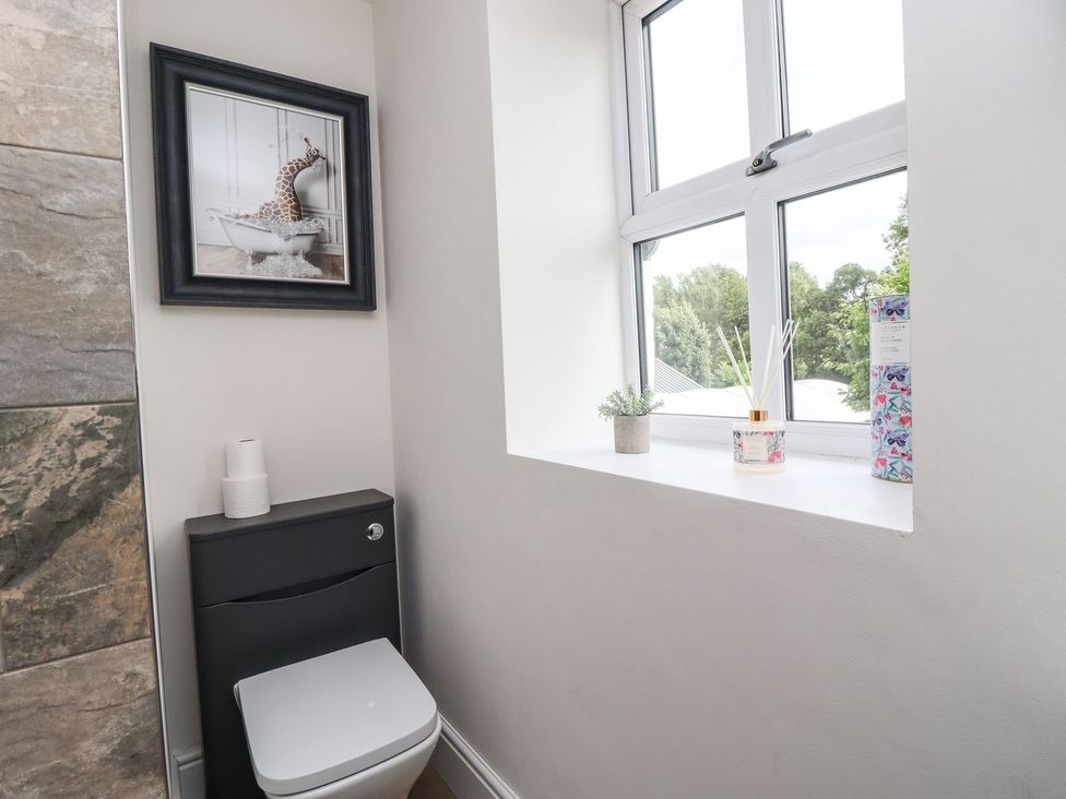 A bathroom with a toilet and window at Cottage by the River in Burnley