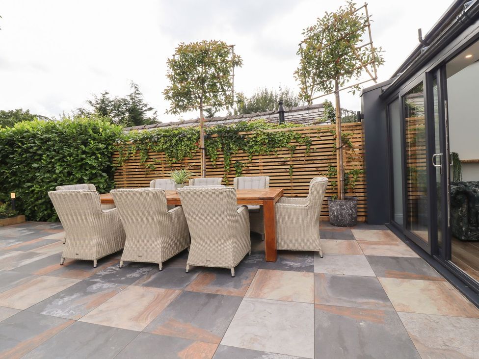 An outdoor dining area with a table and chairs at Cottage by the River in Burnley
