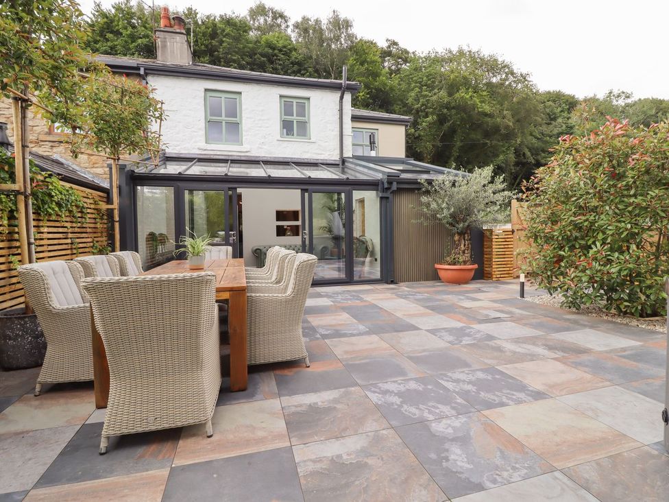 An outdoor dining area with a table and chairs at Cottage by the River in Burnley