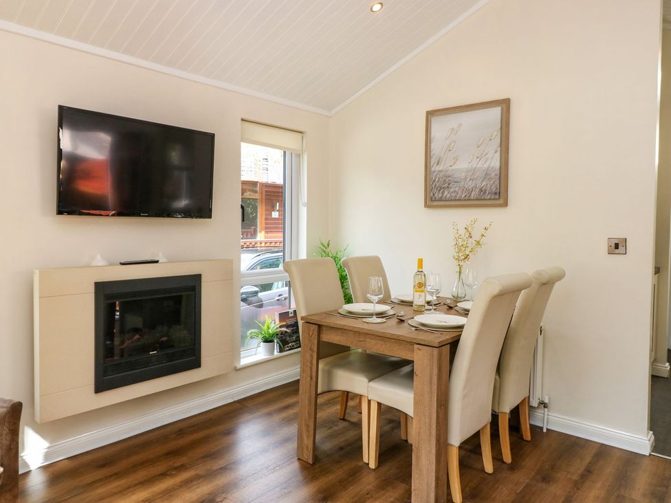 A dining room with a table set for dinner at Fir Tree Lodge Coniston 3, White Cross Bay near Windermere