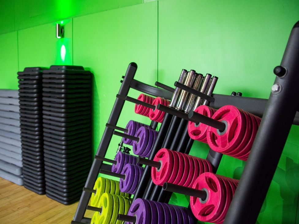 A gym with dumbbell weights and exercise mats at Fir Tree Lodge, Coniston 3, White Cross Bay near Windermere