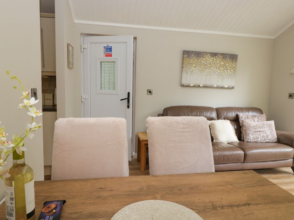 A living room with a sofa and table at Fir Tree Lodge White Cross bay on Windermere, Troutbeck Bridge