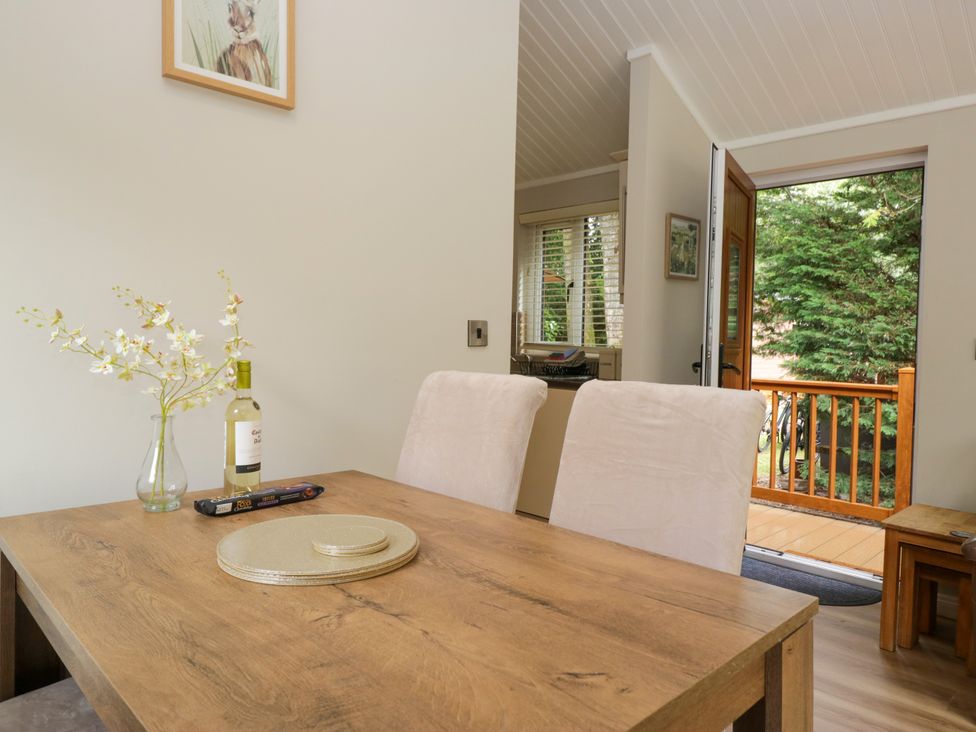 A dining room with a table and chairs at Fir Tree Lodge in White Cross bay on Windermere, Troutbeck Bridge