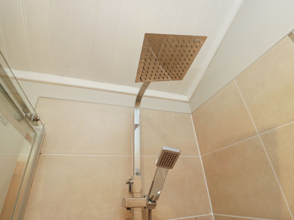A showerhead and handheld shower in a bathroom at Fir Tree Lodge White Cross bay on Windermere Troutbeck Bridge