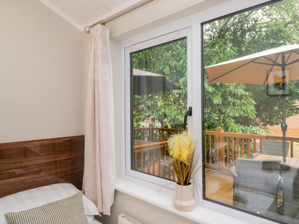 A bedroom with a window view at Fir Tree Lodge White Cross bay on Windermere Troutbeck Bridge