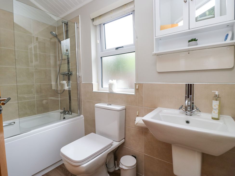 A bathroom with a bathtub, toilet and sink at Fir Tree Lodge in White Cross bay on Windermere, Troutbeck Bridge