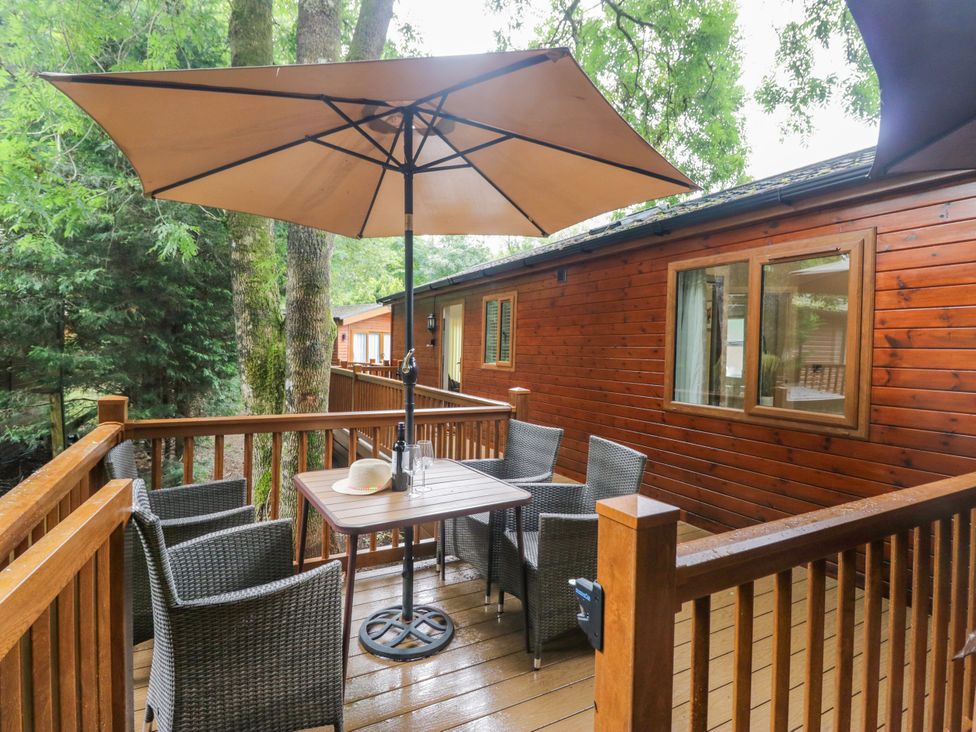 An outdoor seating area with a table and chairs at Fir Tree Lodge White Cross bay on Windermere Troutbeck Bridge