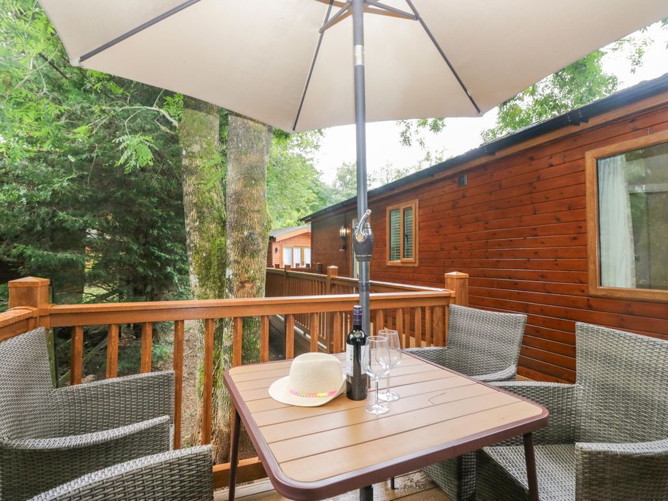An outdoor seating area with a table and chairs at Fir Tree Lodge White Cross bay on Windermere, Troutbeck Bridge