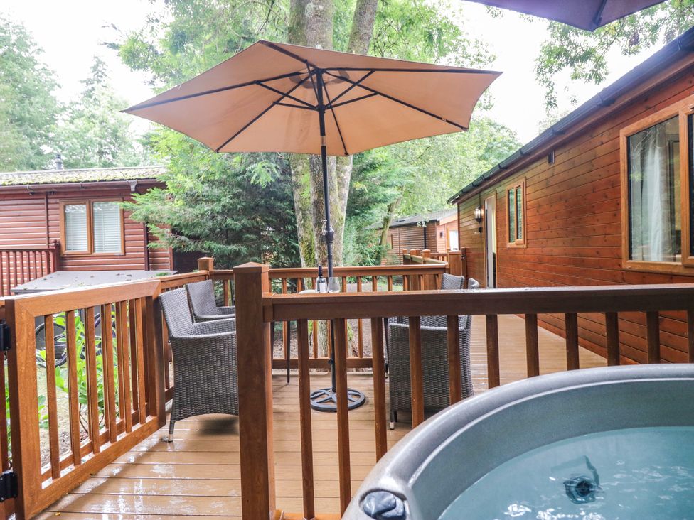 An outdoor area with a hot tub and chairs at Fir Tree Lodge, White Cross bay on Windermere, Troutbeck Bridge