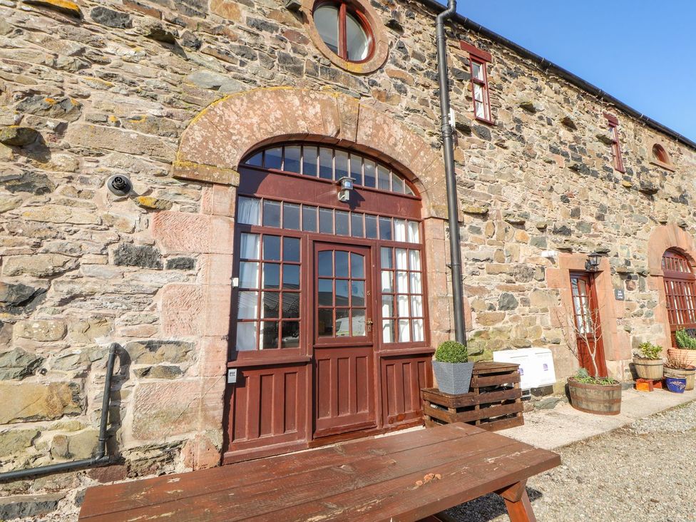 An outdoor area with a wooden door and stone wall at Mellfell Cottage near Watermillock