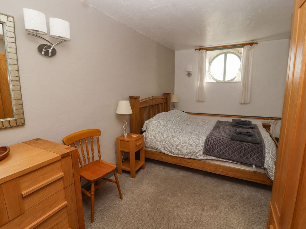 A bedroom with a bed and nightstand at Mellfell Cottage near Watermillock