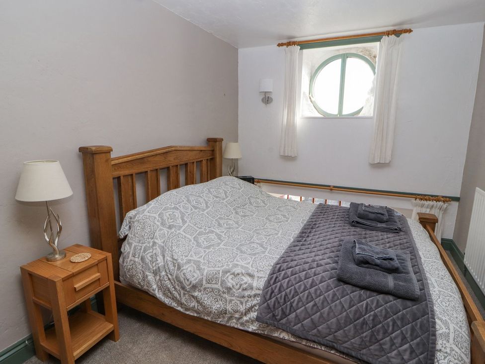 A bedroom with a double bed and bedside table at Mellfell Cottage near Watermillock