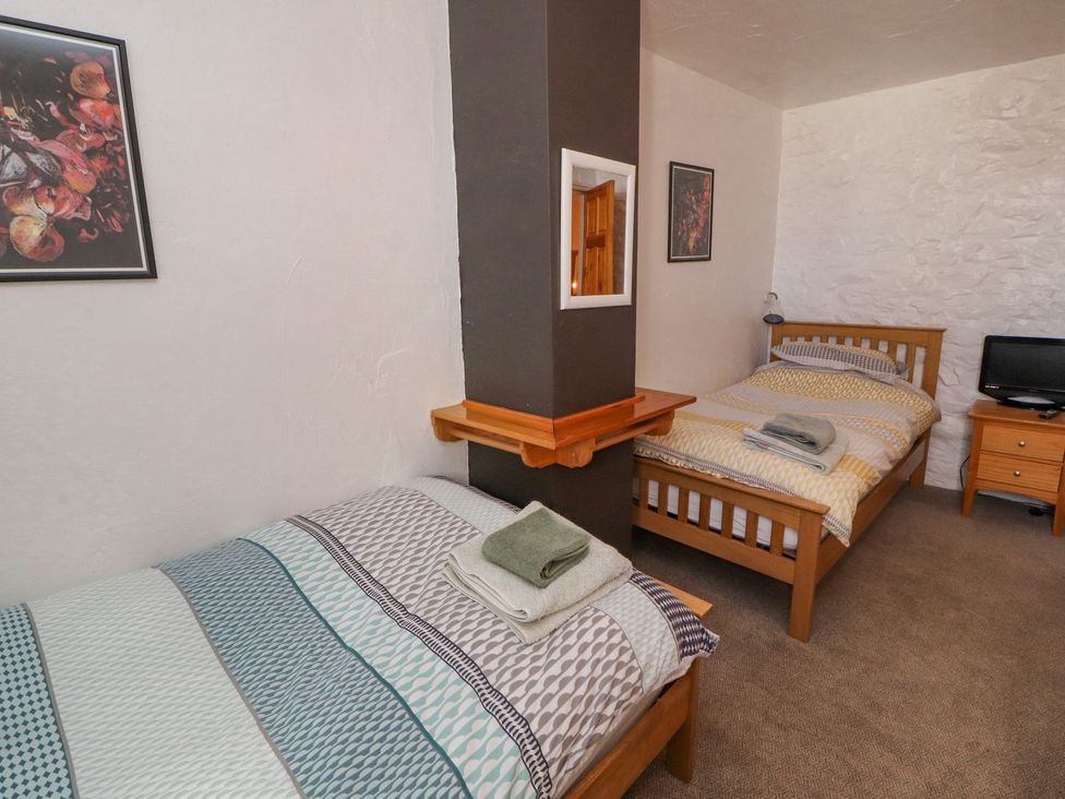 A bedroom with two beds and a television at Mellfell Cottage near Watermillock