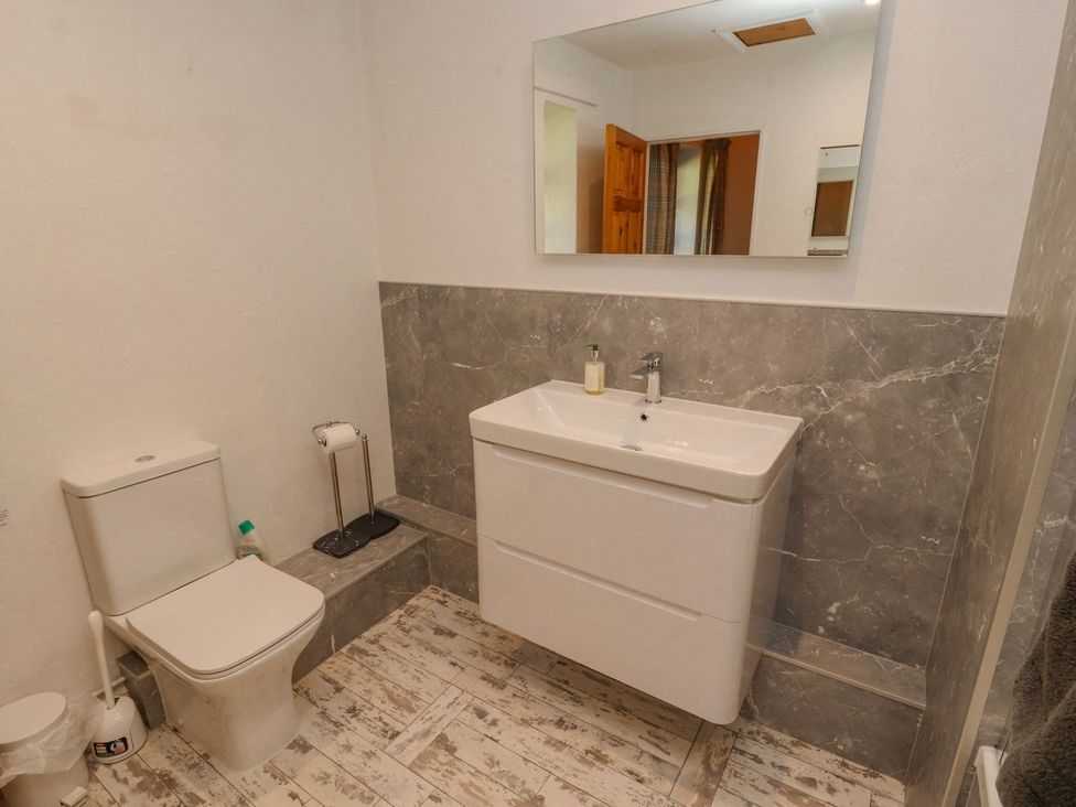 A bathroom with a toilet and wash basin at Mellfell Cottage near Watermillock