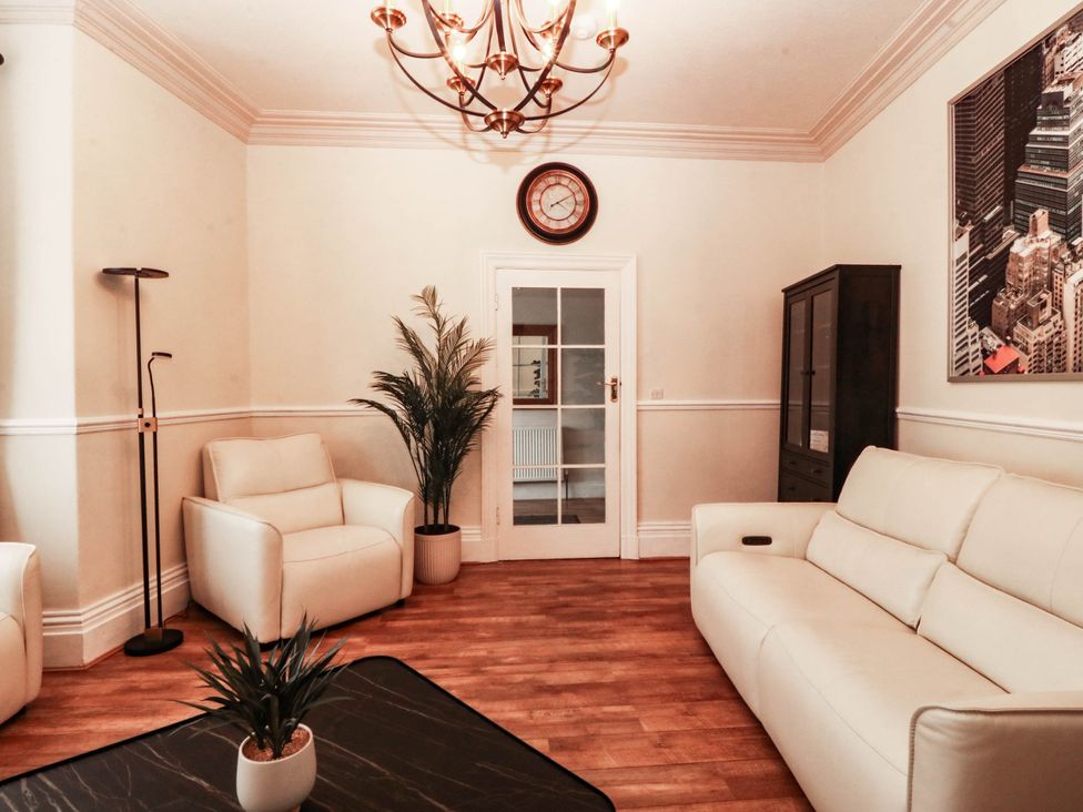 A living room with a sofa and armchair at Tudno Lodge in Llandudno