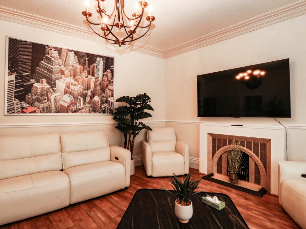 A living room with a sofa and television at Tudno Lodge Llandudno