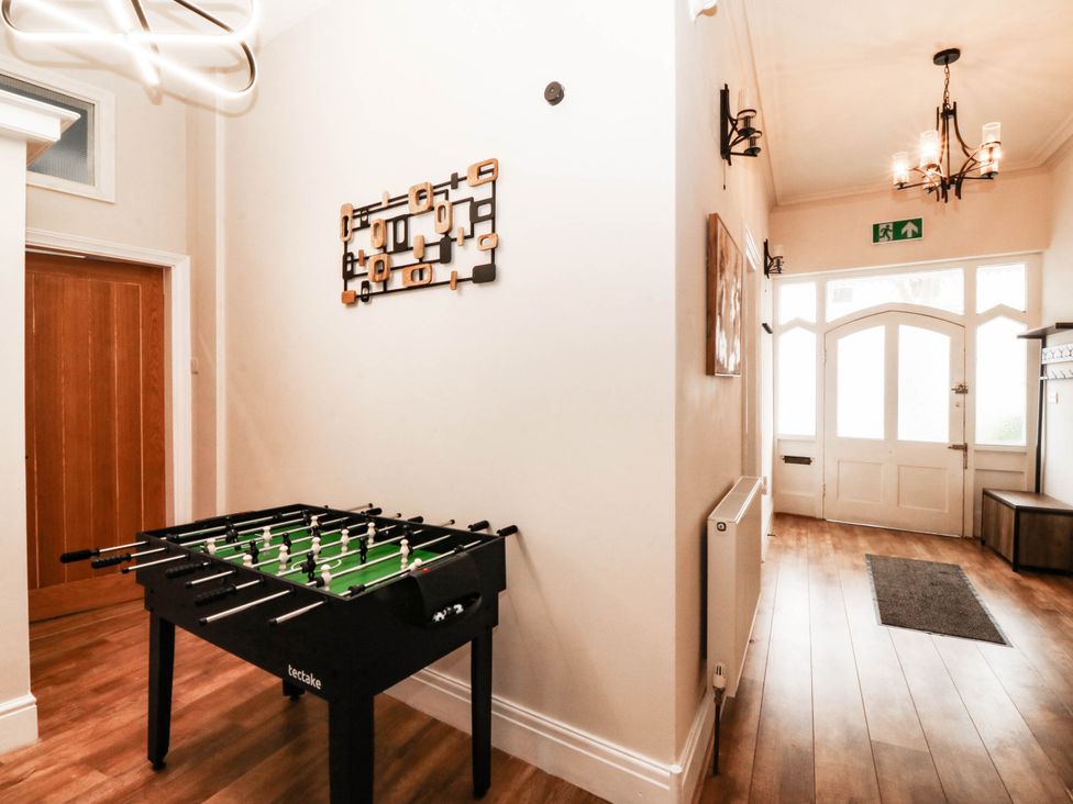 A hallway with a foosball table and a door at Tudno Lodge in Llandudno