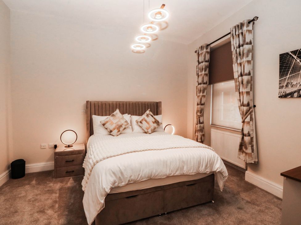 A bedroom with a bed and bedside table at Tudno Lodge in Llandudno