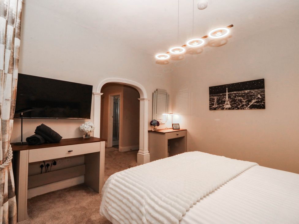 A bedroom with bed, television, and desk at Tudno Lodge in Llandudno