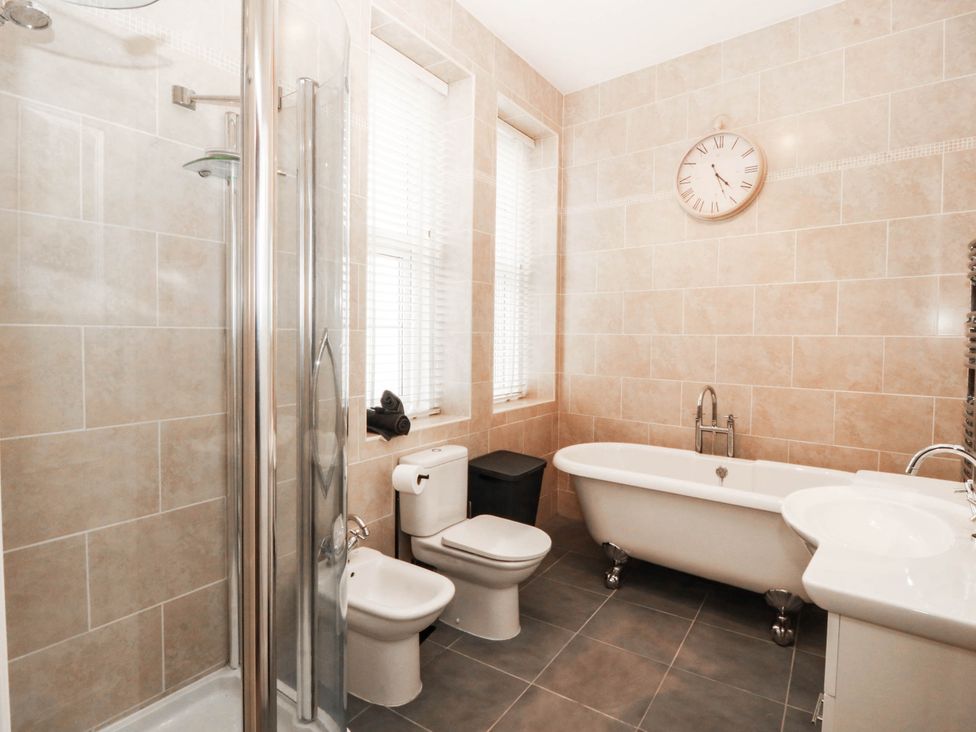 A bathroom with a bathtub, shower, toilet, and sink at Tudno Lodge in Llandudno