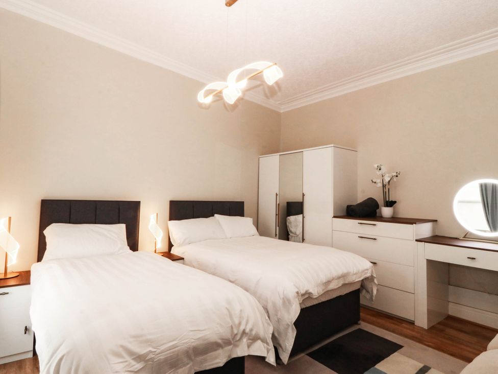 A bedroom with two beds and a dresser at Tudno Lodge in Llandudno