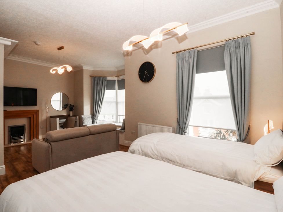 A bedroom with two beds and a sofa at Tudno Lodge in Llandudno