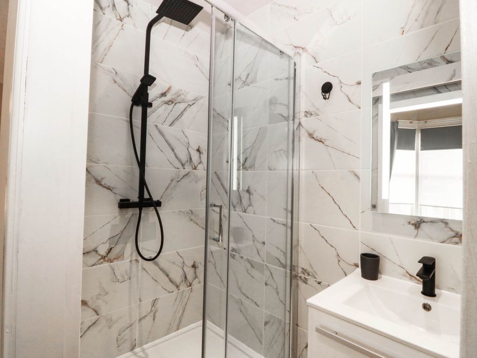 A bathroom with a shower and sink at Tudno Lodge in Llandudno