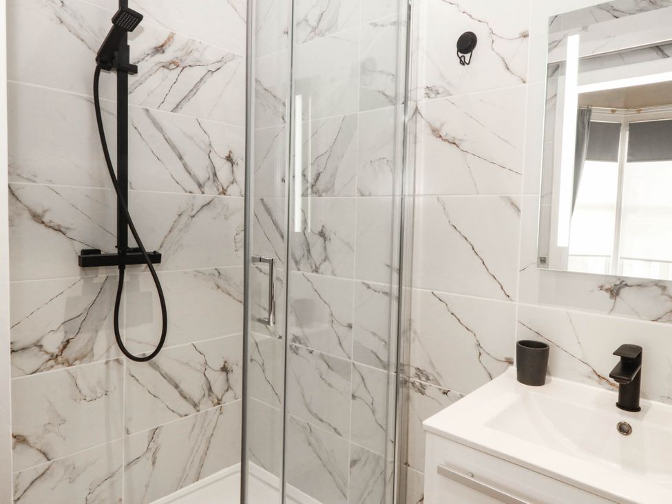A bathroom with a shower and sink at Tudno Lodge in Llandudno