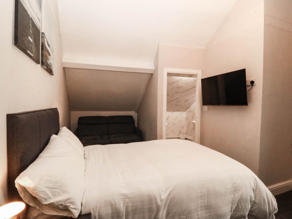 A bedroom with a bed and a sofa at Tudno Lodge in Llandudno