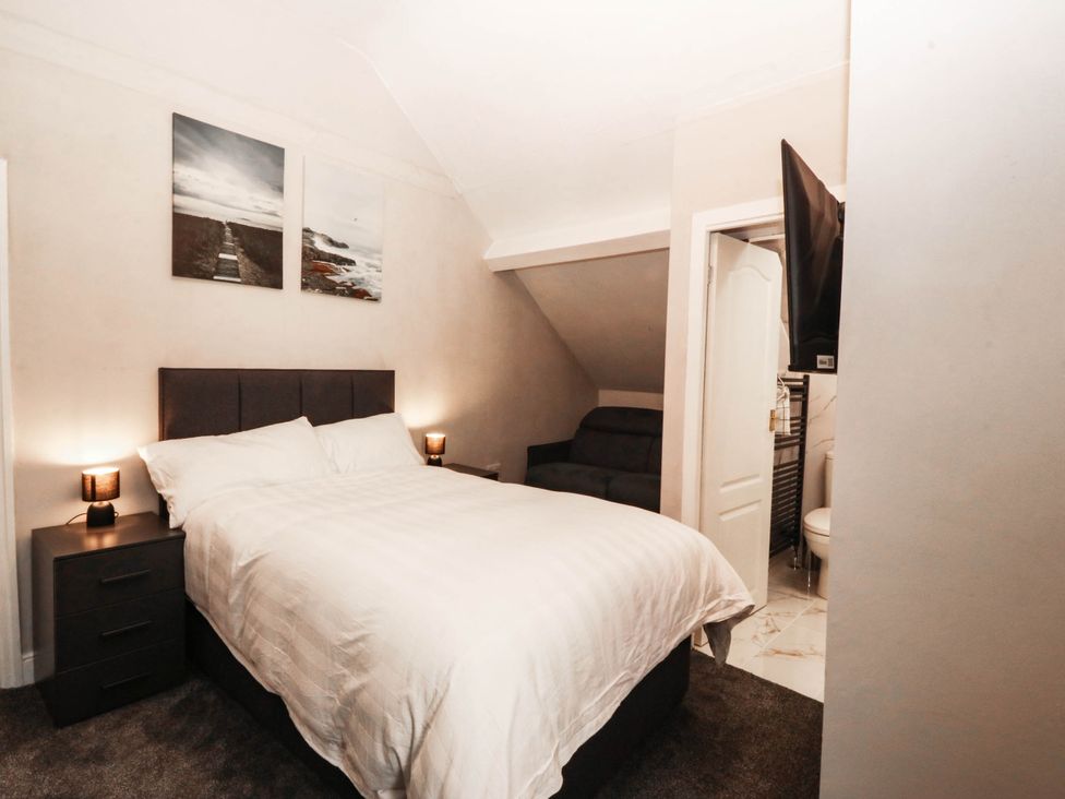 A bedroom with a bed and sofa at Tudno Lodge in Llandudno