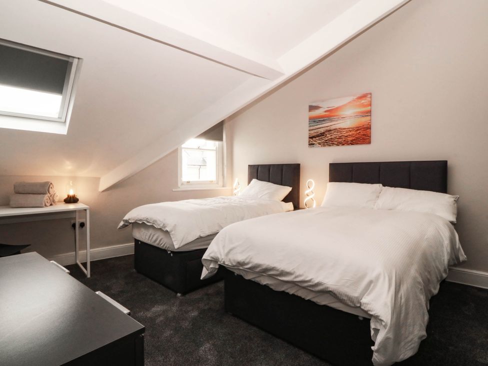 A bedroom with two beds and a nightstand at Tudno Lodge in Llandudno