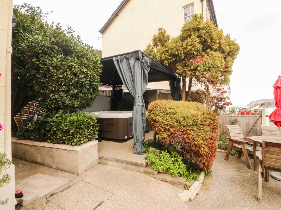 A garden with a hot tub and seating area at Tudno Lodge in Llandudno
