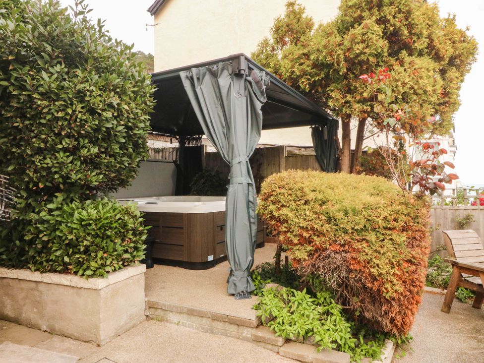 A garden with a hot tub and cabana at Tudno Lodge in Llandudno