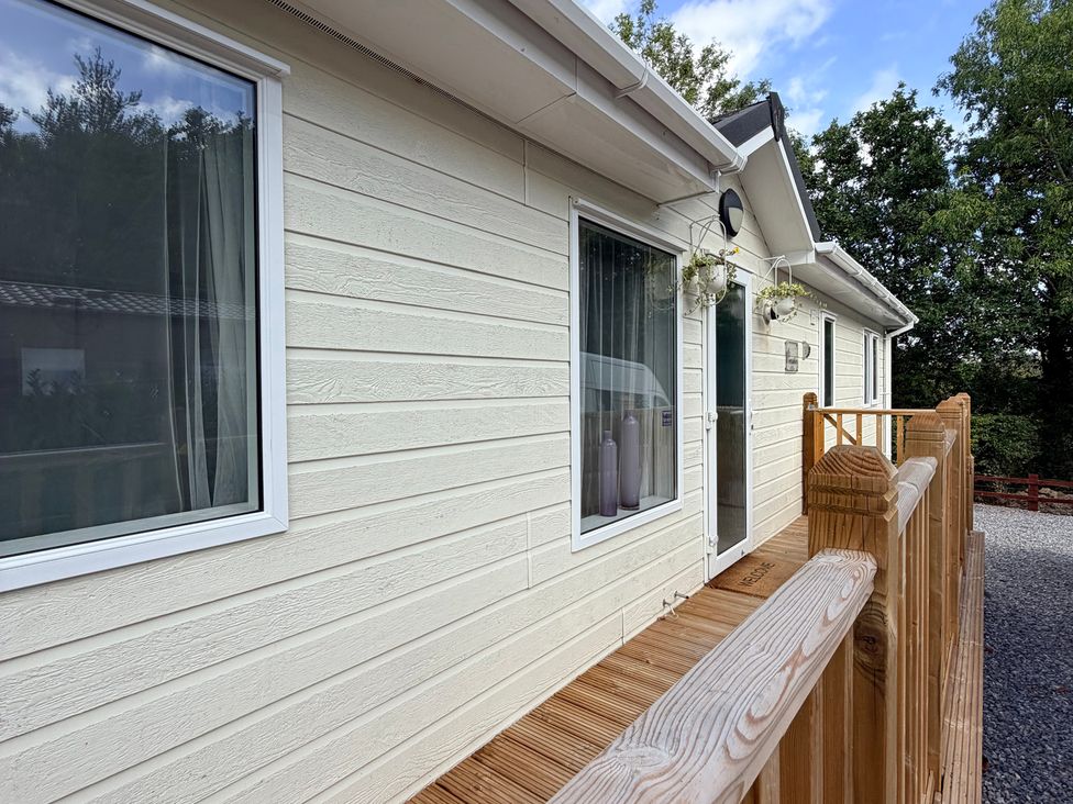 An exterior view of a lodge with a deck at Boutique Lodge Cheriton Bishop