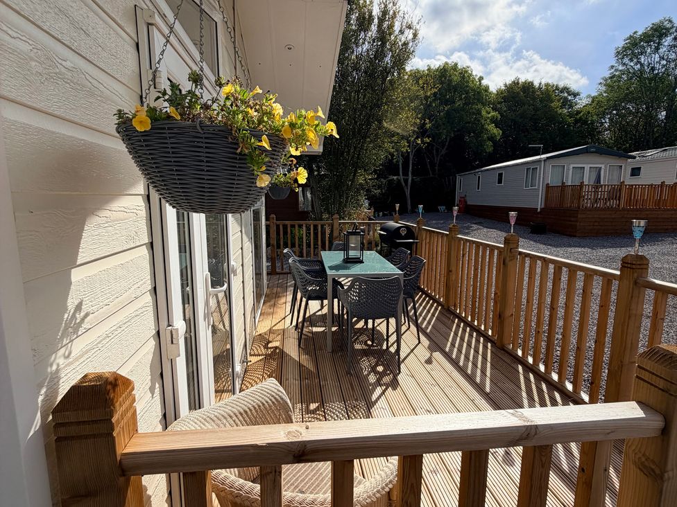 A patio with table and chairs at Boutique Lodge in Cheriton Bishop