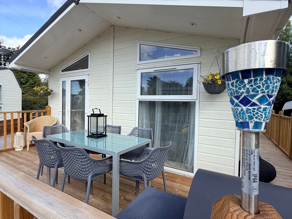 An outdoor seating area with table and chairs at Boutique Lodge in Cheriton Bishop