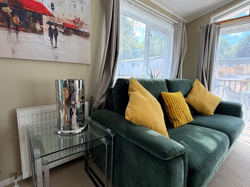 A living room with a green sofa and a coffee table at Boutique Lodge in Cheriton Bishop