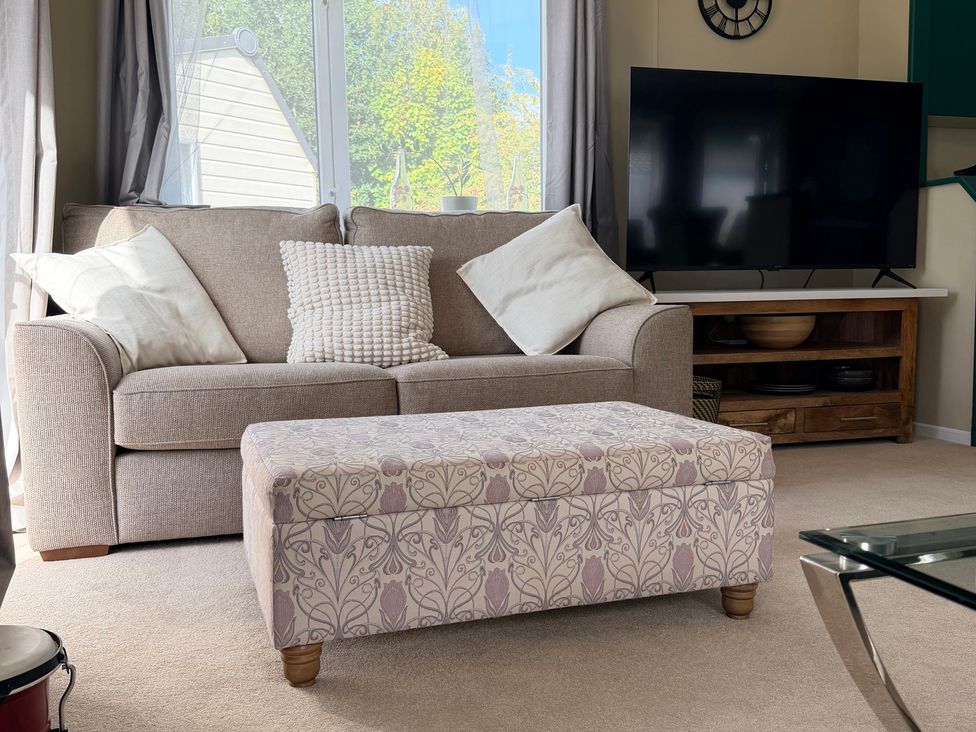 A living room with a sofa and television at Boutique Lodge in Cheriton Bishop