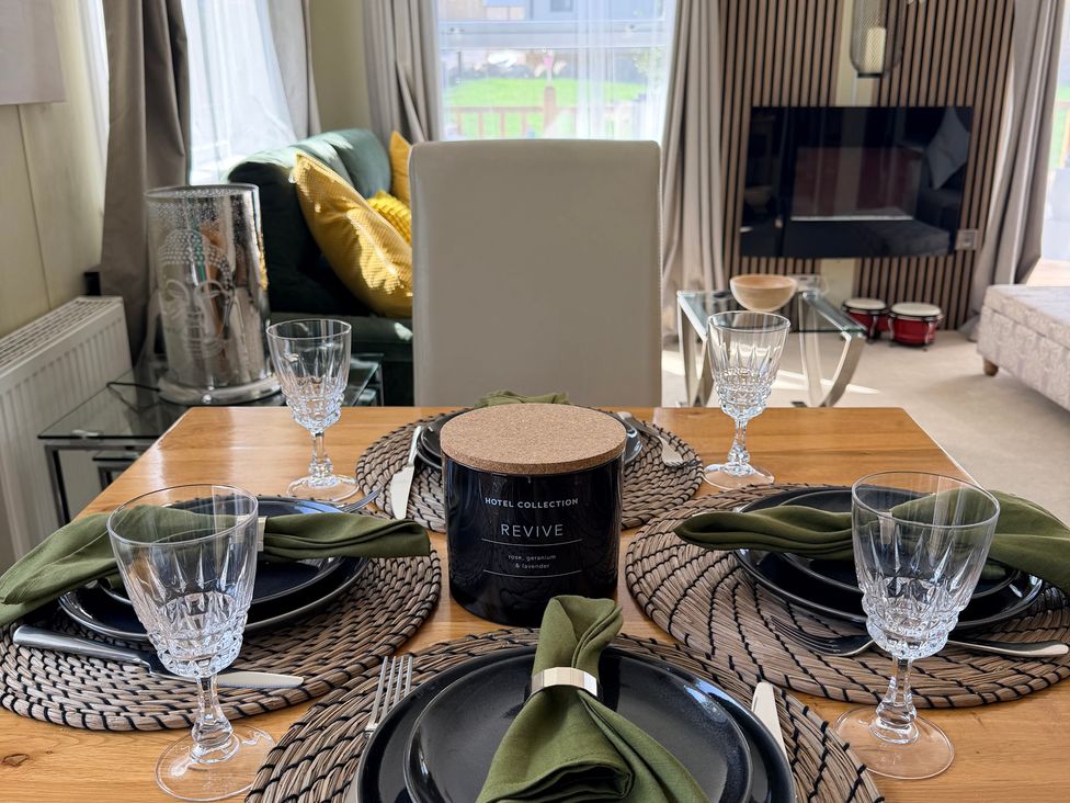 A dining table set with plates and glasses at Boutique Lodge in Cheriton Bishop