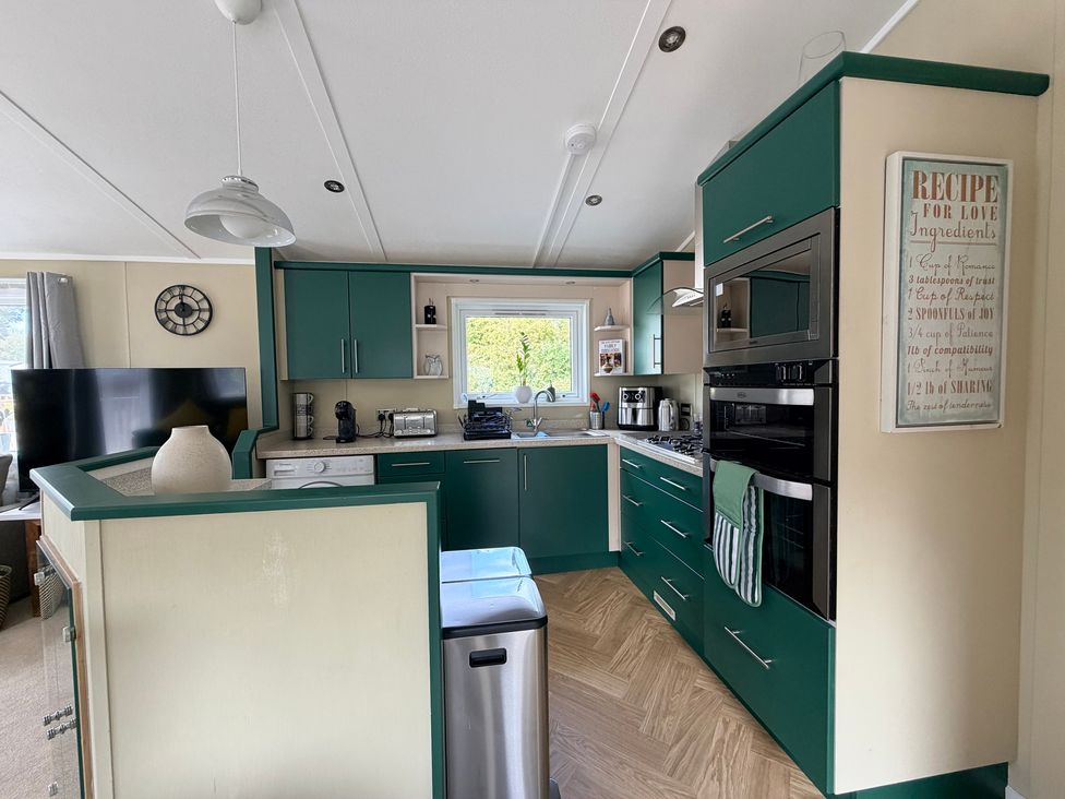 A kitchen with green cabinets and appliances at Boutique Lodge in Cheriton Bishop