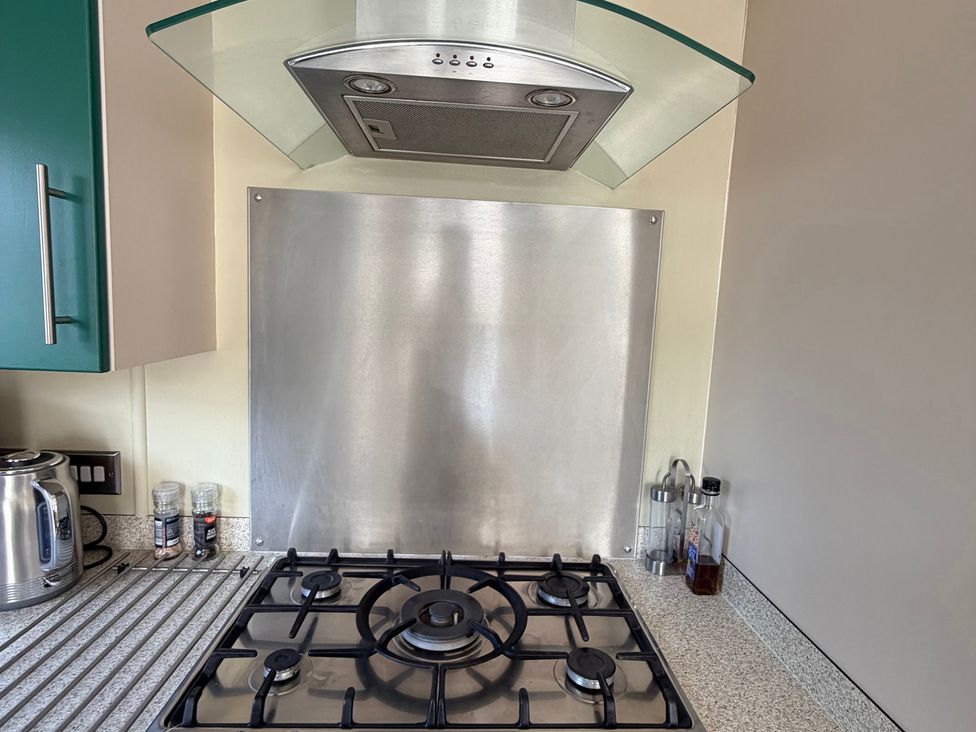 A kitchen with a gas stove and kitchen hood at Boutique Lodge in Cheriton Bishop