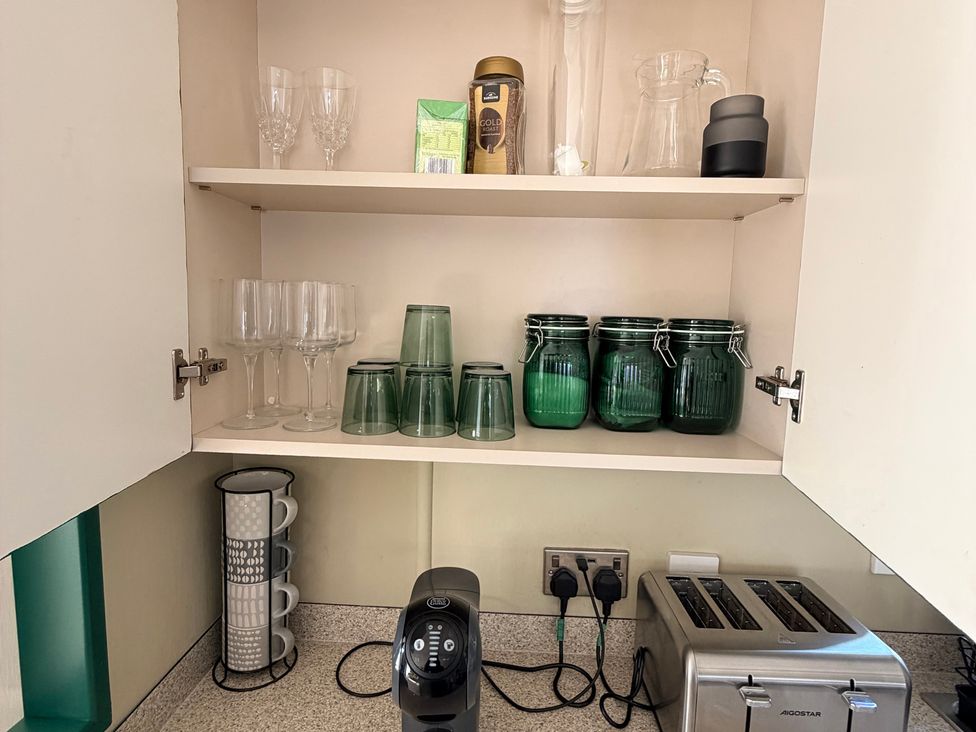 A kitchen with jars and glasses on shelves at Boutique Lodge in Cheriton Bishop